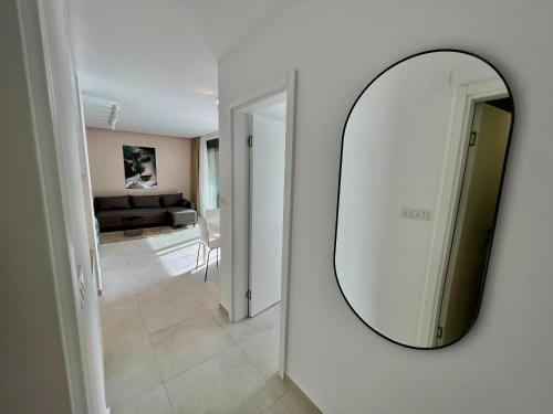 a mirror on a wall next to a living room at Solaris Lux Apartments in Kotor