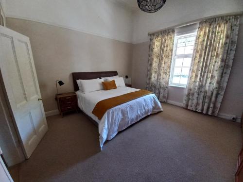 a bedroom with a bed and a window at Karooland Gastehuis in Middelburg