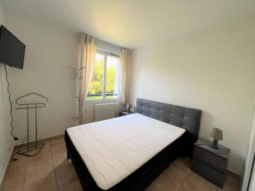 1 dormitorio con cama y ventana en Appartement Cambo-les-Bains, 2 pièces, 2 personnes - FR-1-495-57 en Cambo-les-Bains