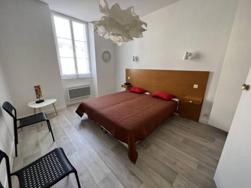 a bedroom with a bed and a table and a chandelier at Appartement Cambo-les-Bains, 2 pièces, 3 personnes - FR-1-495-79 in Cambo-les-Bains