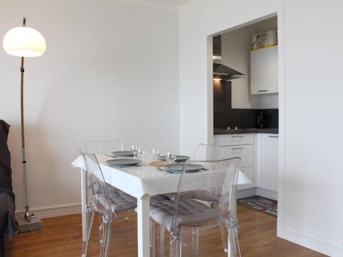 - une table à manger blanche avec des chaises dans la cuisine dans l'établissement Appartement rénové face mer avec terrasse, box privatif, 2 pièces, 4 couchages - Pornichet - FR-1-245-132, à Pornichet