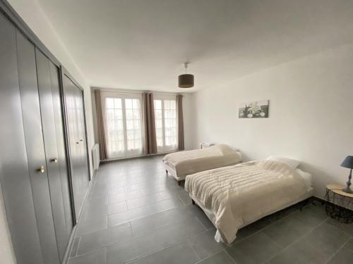 Habitación con 2 camas, paredes blancas y suelo de baldosa. en Appartement La Roche-Posay, 3 pièces, 4 personnes - FR-1-541-15, en La Roche-Posay