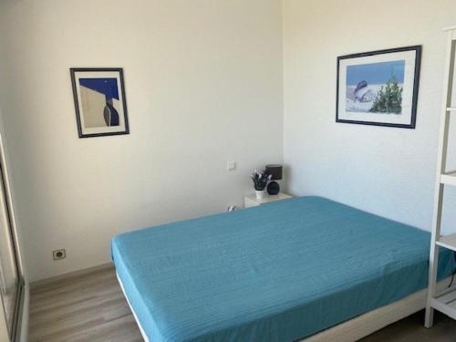 1 dormitorio con 1 cama y 2 cuadros en la pared en Appartement Royan, 2 pièces, 4 personnes - FR-1-494-33, en Royan
