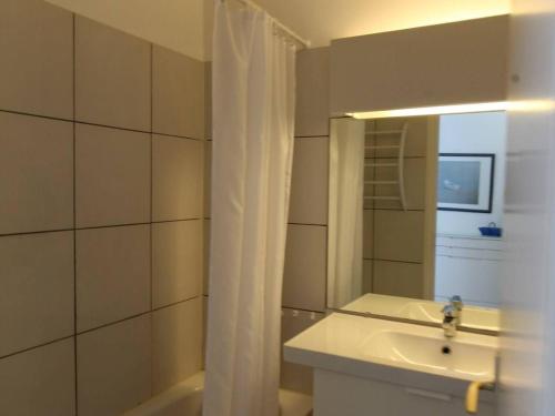 y baño con lavabo y espejo. en Appartement Royan, 2 pièces, 4 personnes - FR-1-494-33, en Royan
