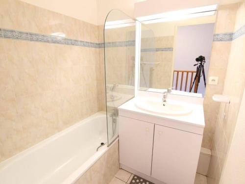 une salle de bain avec un lavabo, une baignoire et un miroir dans l'établissement Appartement familial 6 pers à 500m des télécabines - Serre Chevalier Vallée - FR-1-330F-194, à La Salle Les Alpes