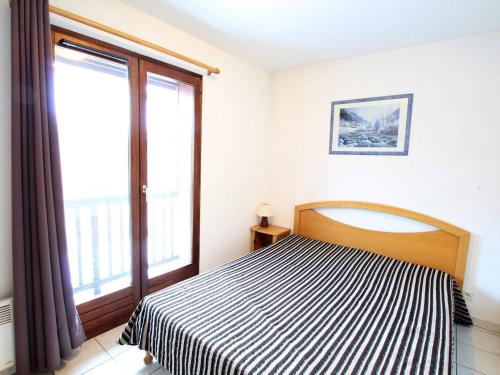 une chambre avec un lit et une grande fenêtre dans l'établissement Appartement familial 6 pers à 500m des télécabines - Serre Chevalier Vallée - FR-1-330F-194, à La Salle Les Alpes