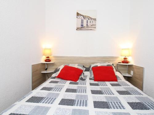 une chambre avec un lit avec deux oreillers rouges dans l'établissement Charmant T1 avec grande terrasse, climatisé, proche des Thermes, équipé lave-vaisselle et lave-linge - FR-1-553-43, à Balaruc-les-Bains