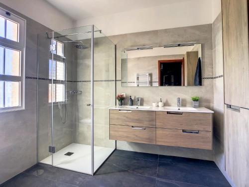 a bathroom with a glass shower and a sink at Villa Baradaye by LovelyStay in Estreito da Calheta