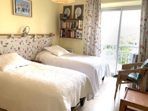deux lits dans une chambre avec une fenêtre dans l'établissement Bel appartement lumineux avec balcon, proche Thermes, 1 chambre, animaux admis, WIFI - FR-1-503-72, à Balaruc-les-Bains
