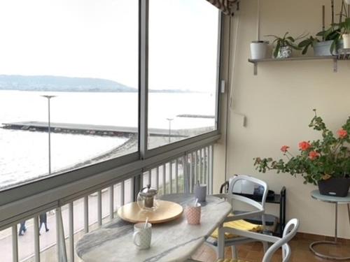 un balcon avec une table et une vue sur l'océan dans l'établissement Bel appartement lumineux avec balcon, proche Thermes, 1 chambre, animaux admis, WIFI - FR-1-503-72, à Balaruc-les-Bains