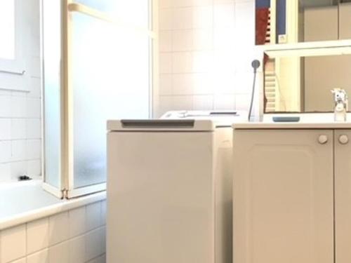 une salle de bain blanche avec un lavabo et un miroir dans l'établissement Bel appartement lumineux avec balcon, proche Thermes, 1 chambre, animaux admis, WIFI - FR-1-503-72, à Balaruc-les-Bains