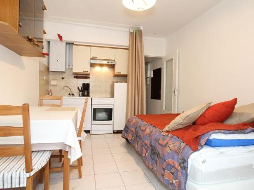 une chambre avec un lit et une petite cuisine dans l'établissement Studio fonctionnel avec loggia fermée à Balaruc-les-Bains, proche centre, parking collectif, tout équipé - FR-1-553-112, à Balaruc-les-Bains