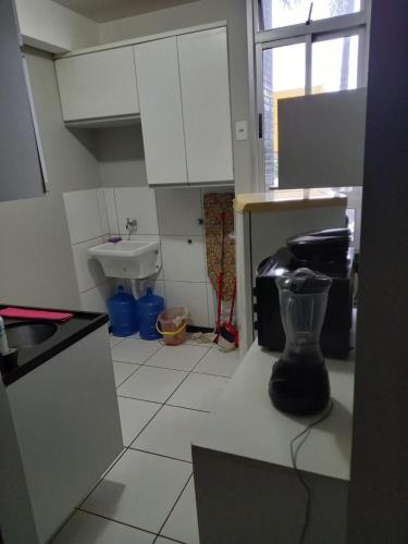 uma cozinha com um lavatório e um liquidificador no balcão em flat em Brasília