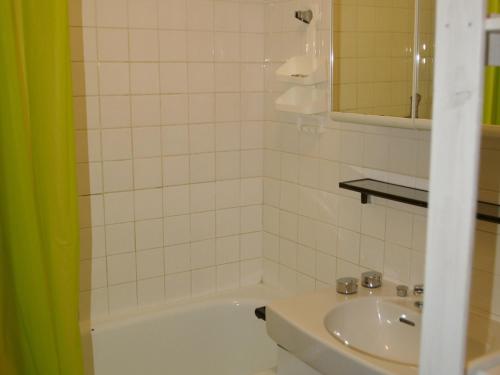 une salle de bain avec une baignoire blanche et un lavabo dans l'établissement 3 pièces au pied des pistes avec balcon - 2 chambres, parking, appareil à raclette - FR-1-557-5, à Les Adrets
