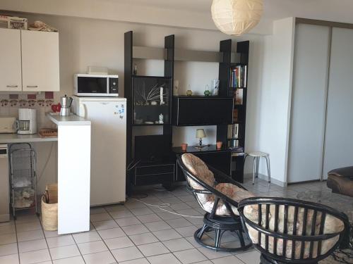 Il comprend une cuisine équipée d'un réfrigérateur et d'une table avec une chaise. dans l'établissement Appartement T3 avec parking à Argelès-sur-Mer, 2 chambres, cuisine équipée pour 4/6 pers. - FR-1-388-187, à Argelès-sur-Mer
