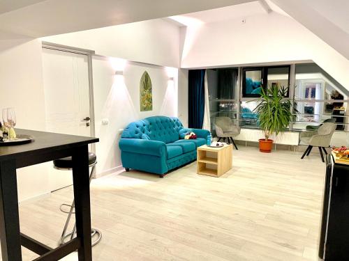 a living room with a blue couch and a table at Floria Hotels in Voluntari