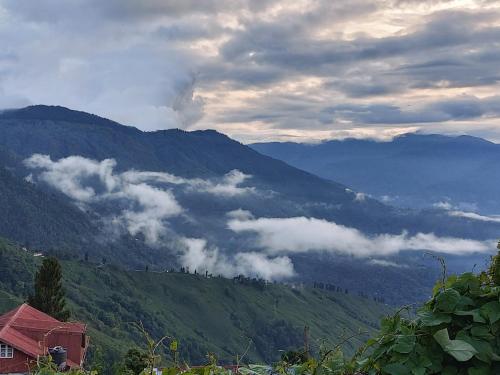 a view of a mountain with clouds in the valley at Hotel Sakura in Darjeeling