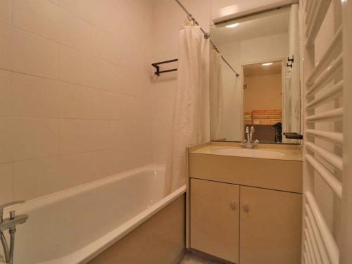 une salle de bain avec une baignoire, un lavabo et un miroir dans l'établissement Studio 4 pers au pied des pistes, proche commodités, avec cuisine équipée et casier à skis - FR-1-398-608, à Montvalezan