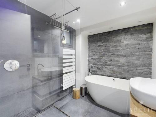 La salle de bains est pourvue d'une baignoire, d'un lavabo et d'une baignoire. dans l'établissement Superbe Duplex Savoyard pour 13 pers. avec Cheminée et Balcons, à 300m des Pistes - FR-1-398-616, à Montvalezan