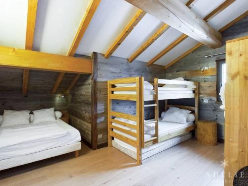 Ce lit se trouve dans un dortoir doté de 2 lits superposés et de murs en bois. dans l'établissement Superbe Duplex Savoyard pour 13 pers. avec Cheminée et Balcons, à 300m des Pistes - FR-1-398-616, à Montvalezan