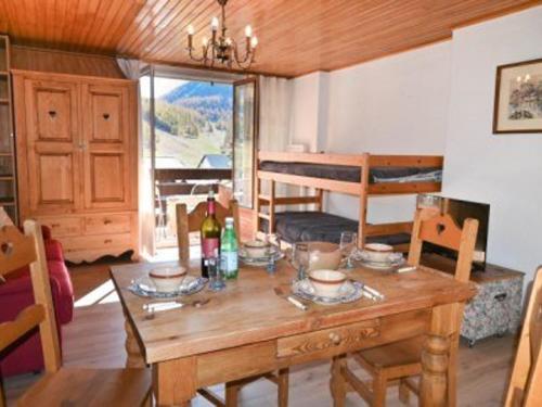 - une salle à manger avec une table en bois et des bouteilles de vin dans l'établissement Studio cosy 4 pers avec balcon et parking à Montgenèvre - FR-1-266-159, à Montgenèvre