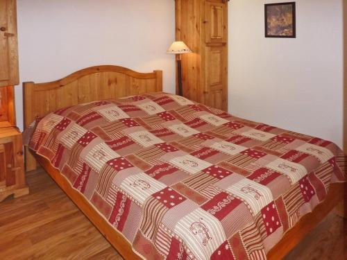 萊索爾的住宿－Appartement Les Orres, 2 pièces, 6 personnes - FR-1-322-382，卧室内的一张床位,配有红色和棕色的毯子
