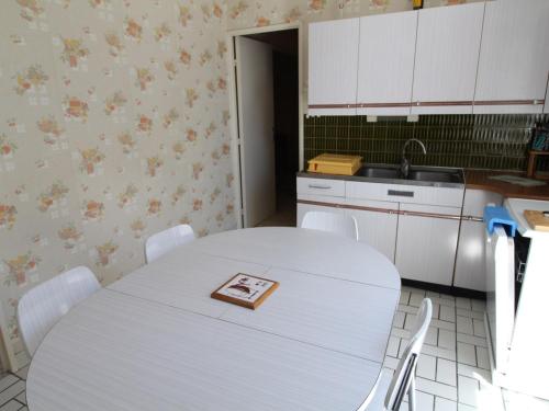 - une cuisine avec une table blanche et un livre dans l'établissement Maison de plain-pied avec jardin clos, proche de la plage et des commerces - FR-1-494-58, à Saint-Georges-de-Didonne