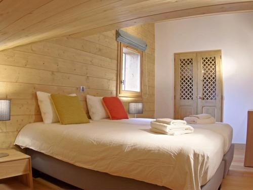 a bedroom with a large white bed with wooden walls at Appartement Valmorel, 4 pièces, 8 personnes - FR-1-291-833 in Valmorel