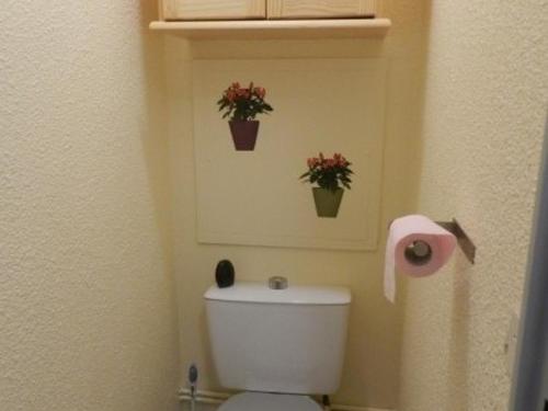 La salle de bains est pourvue de toilettes avec 2 plantes sur le mur. dans l'établissement Studio cabine au pied des pistes - FR-1-557A-7, à La Ferrière