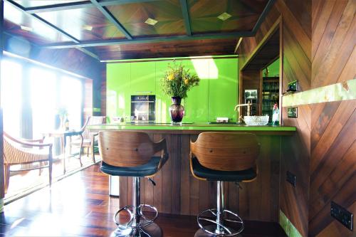 a kitchen with a green counter with two stools at Belmont Penthouse Apartment in Bristol
