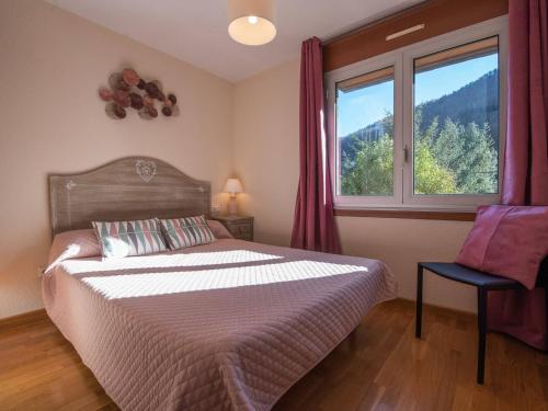 une chambre avec un lit et une grande fenêtre dans l'établissement Appartement T3 pour 4 pers. à Saint Lary Village, proche centre et téléphérique - FR-1-296-304, à Saint-Lary-Soulan