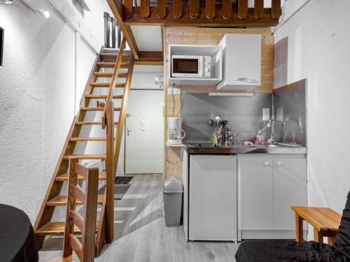 une petite cuisine avec une échelle menant à un petit appartement dans l'établissement Charmant Duplex 18m² à 150m des Pistes, Centre Cauterets, Parking Gratuit - FR-1-401-195, à Cauterets