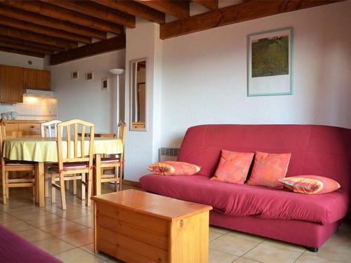 un salon avec un canapé rouge et une table dans l'établissement Charmant T3 avec Parking, Proche des Pistes, Equipé pour Familles - FR-1-593-14, aux Angles