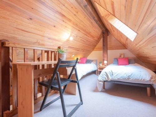 Cette chambre mansardée comprend deux lits et un bureau. dans l'établissement Appartement Triplex à Saint-Lary, 4 chambres, 9 pers, balcon, parking, WiFi optionnel - FR-1-296-287, à Saint-Lary-Soulan