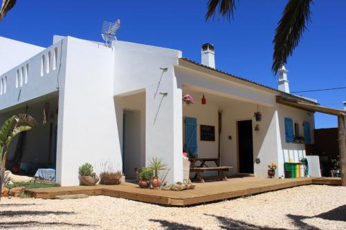 een wit huis met een veranda en een patio bij PuraVida Divehouse in Sagres