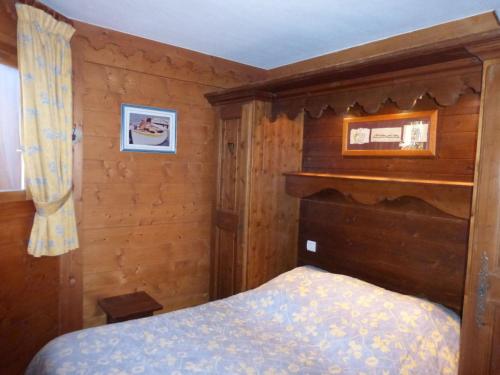 een slaapkamer met een bed en een houten muur bij Appartement Méribel, 3 pièces, 4 personnes - FR-1-411-618 in Les Allues