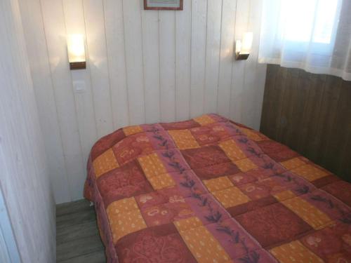 een bed in een kamer met een quilt bij Appartement Saint-Lary-Soulan, 5 pièces, 8 personnes - FR-1-457-169 in Saint-Lary-Soulan