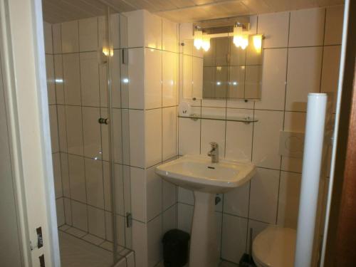 een badkamer met een wastafel en een douche met een spiegel bij Appartement Saint-Lary-Soulan, 5 pièces, 8 personnes - FR-1-457-169 in Saint-Lary-Soulan
