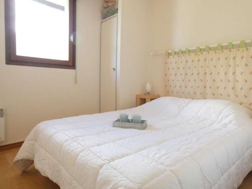 Schlafzimmer mit einem großen weißen Bett und einem Fenster in der Unterkunft Appartement Saint-Lary-Soulan, 2 pièces, 4 personnes - FR-1-457-160 in Saint-Lary-Soulan