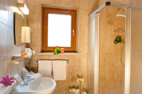 un baño con lavabo y ducha en Pension Felseneck, en San Leonardo in Passiria