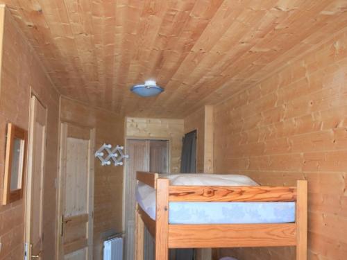 un lit dans une chambre avec un plafond en bois dans l'établissement Charmant T2 cabine 35m² avec terrasse, exposition sud-ouest, bien équipé, Bolquère, sans animaux - FR-1-592-37, à Bolquère-Pyrénées 2000