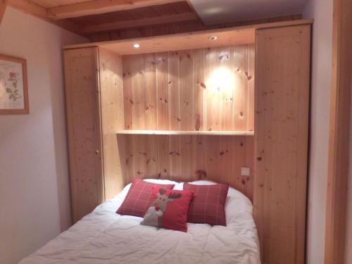 - une chambre avec un lit et un mur en bois dans l'établissement Charmant T2 cabine pour 4 près du centre et commerces à Méribel, parking inclus - FR-1-411-677, à Les Allues