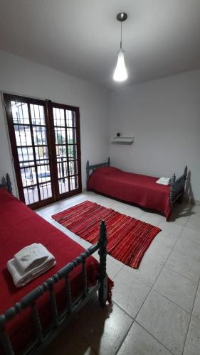 a bedroom with two beds and a red rug at Nieva 4M in San Salvador de Jujuy