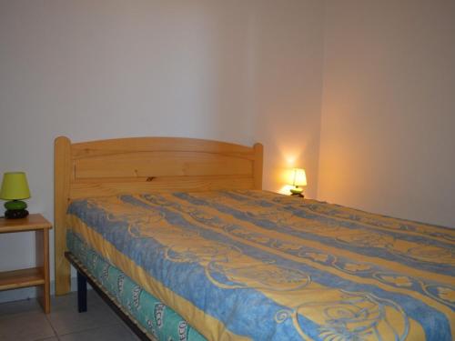 - une chambre dotée d'un lit avec une couverture bleue et jaune dans l'établissement Appartement front de mer avec piscine, 6 couchages, animaux admis - FR-1-225D-83, à Saint Cyprien Plage