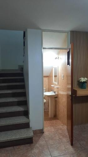 a hallway with a staircase and a bathroom with a sink at Nieva 4M in San Salvador de Jujuy