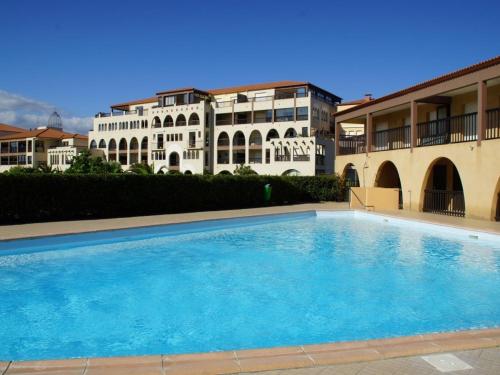 une grande piscine devant un immeuble dans l'établissement Appartement front de mer avec piscine, 6 couchages, animaux admis - FR-1-225D-83, à Saint Cyprien Plage