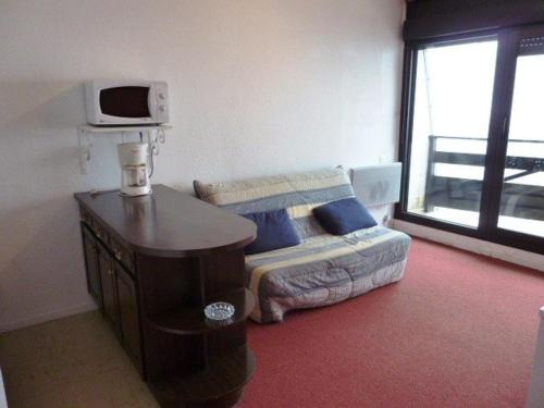 - une chambre avec un lit et une table avec un four micro-ondes dans l'établissement Studio 6 pers au pied des pistes avec balcon, casier à skis et parking gratuit - FR-1-602-27, à Arette