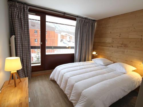 une chambre avec un grand lit et une grande fenêtre dans l'établissement Appartement rénové 6 pers. avec balcon et parking privé à Montgenèvre - FR-1-330D-115, à Montgenèvre