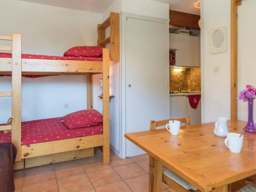 Cette chambre comprend 2 lits superposés et une table. dans l'établissement Appartement Montgenèvre, 1 pièce, 2 personnes - FR-1-330D-1, à Montgenèvre