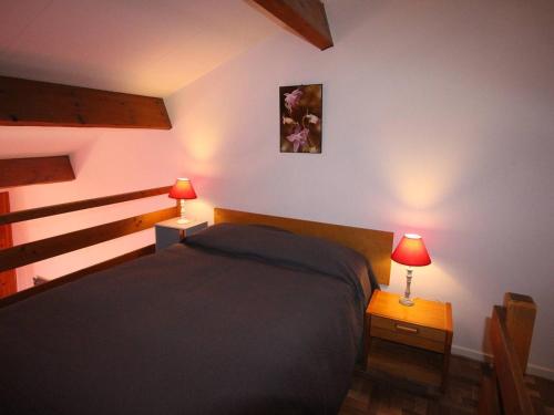 ein Schlafzimmer mit einem Bett und zwei Lampen an Tischen in der Unterkunft Studio Bagnères-de-Luchon, 1 pièce, 4 personnes - FR-1-313-124 in Luchon